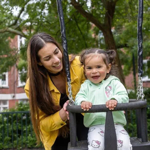 Moeder met kind op schommel